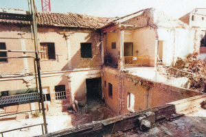 Teilweise abgerissenes Gebäude mit Barrikade, sichtbaren Fenstern und etwas, das wie eine Leiter aussieht.