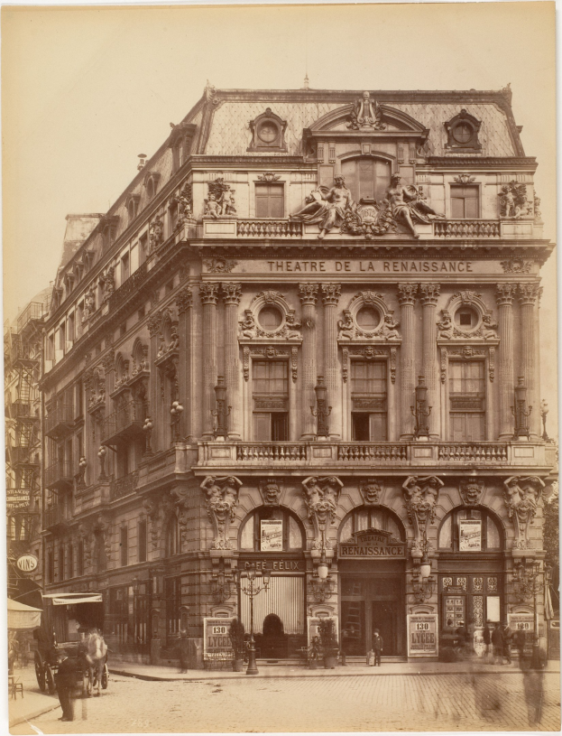 Alte Fotografie des Théâtre de la Renaissance in Paris, das seine Fassade mit Fenstern, Säulen, Bögen und Skulpturen zeigt, mit einigen Menschen und Fahrzeugen davor und dem Himmel im Hintergrund.
