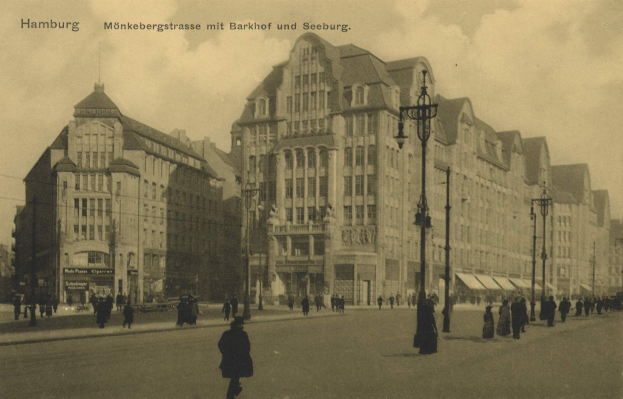 Schwarzes und weißes Foto einer Straßen Szene in Hamburg, Deutschland, mit Fußgängern, Gebäuden, Straßenmasten, Laternen und Fahrzeugen unter einem bewölkten Himmel.
