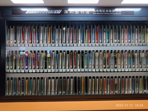 Eine gut beleuchtete Bibliothek mit hohen Bücherregalen voller Bücher, mit einer Texttafel und einem stadtblockartigen Wasserzeichen.