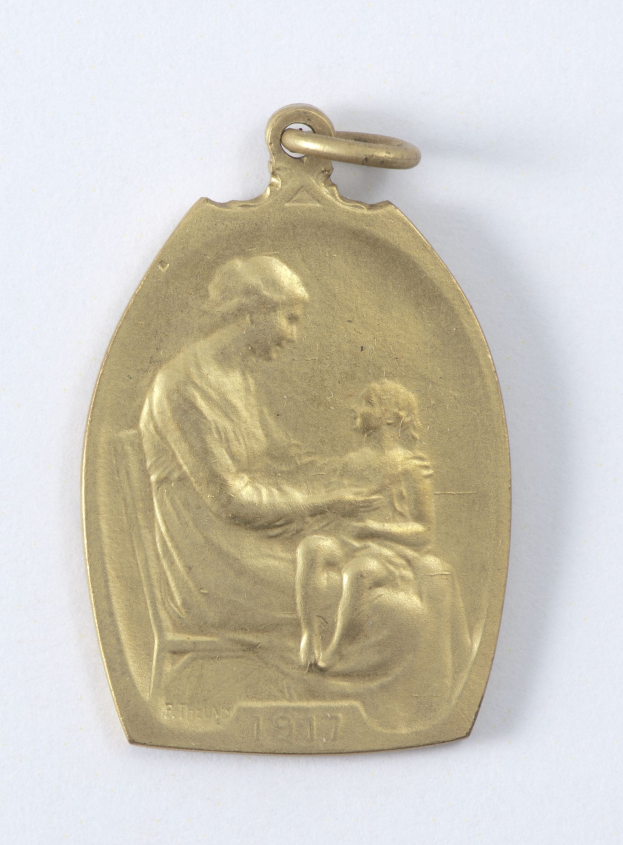 Goldmedaille mit einer Gravur einer Frau in einem weißen Kleid mit einem Dutt, die ein Kind hält, beide schauen sich an, mit den Worten "Mutter und Kind" in Kursivschrift.