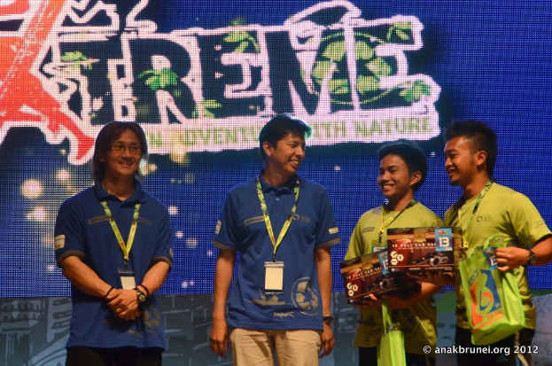 Menschen mit ID-Karten stehend mit einem Plakat im Hintergrund.
