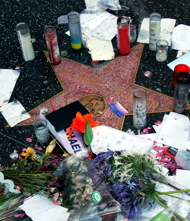 Star auf dem Hollywood Walk of Fame umgeben von Blumen, Kerzen, Papieren und anderen Huldigungen.