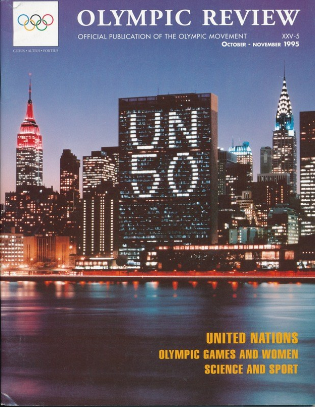 Buch mit dem Titel "Olympische Spiele: Offizielle Publikation der Olympischen Bewegung" mit einer Stadtansicht auf dem Cover, das auf einer flachen Oberfläche liegt.