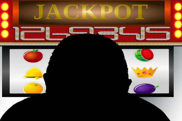 Ein Mann spielt ein Online-Slot-Spiel mit einer "Jackpot"-Anzeige, umgeben von fruchtmotivischen Symbolen auf einer digitalen Tafel.