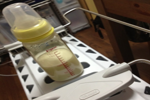 Eine klare Glas-Milchflasche mit einer silbernen Kappe.