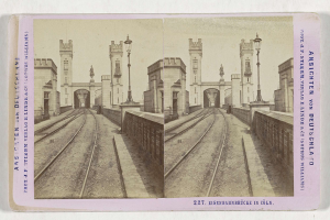 Schwarz-weißes stereoskopisches Foto einer Eisenbahnbrücke in Köln, Deutschland, mit Eisenbahnschienen, Wänden, Pfählen, Statuen, Himmel und Text.