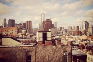 Eine Luftaufnahme einer Stadt mit zahlreichen Geb├Ąuden und einem bew├Âlktem Himmel.