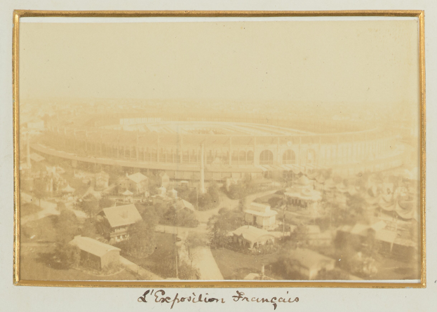 Altes Schwarz-Weiß-Foto eines Stadions in städtischer Umgebung mit umliegenden Gebäuden, Bäumen und Strommasten, das unten Text enthält.