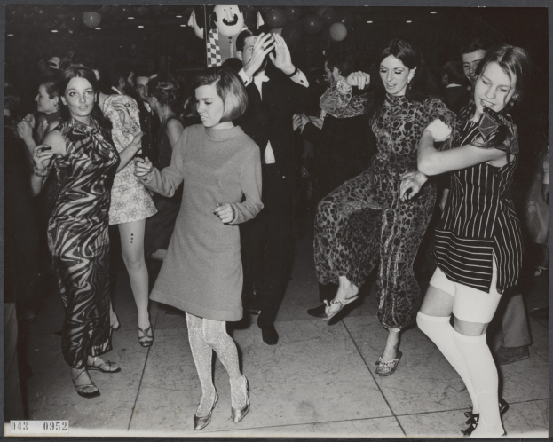Schwarzes und weißes Bild einer Gruppe von Frauen, die auf einer beleuchteten Tanzfläche tanzen, umgeben von Ballons mit Text unten.