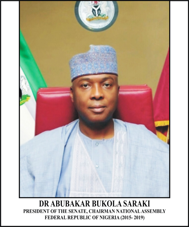 Dr. Abubakar Bukola Saraki, Präsident des Senats und Vorsitzender der Nationalversammlung, sitzt in einem blauen Gewand und Hut, mit zwei Flaggen und einer logogeschmückten Wand im Hintergrund; ein Rahmen mit Inschrift darunter