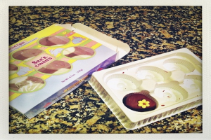 Ein Kasten mit Tierbildern und Text neben einer Speiseplatte, die auf einem steinernen Sockel steht.