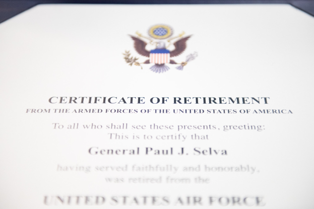 Rahmenurkunde der United States Air Force mit blauer Einfassung, zentralem Sternschild-Logo innerhalb eines Lorbeerkranzes und einer 'Retirement'-Bannerschrift, alles in Schwarz gedruckt.