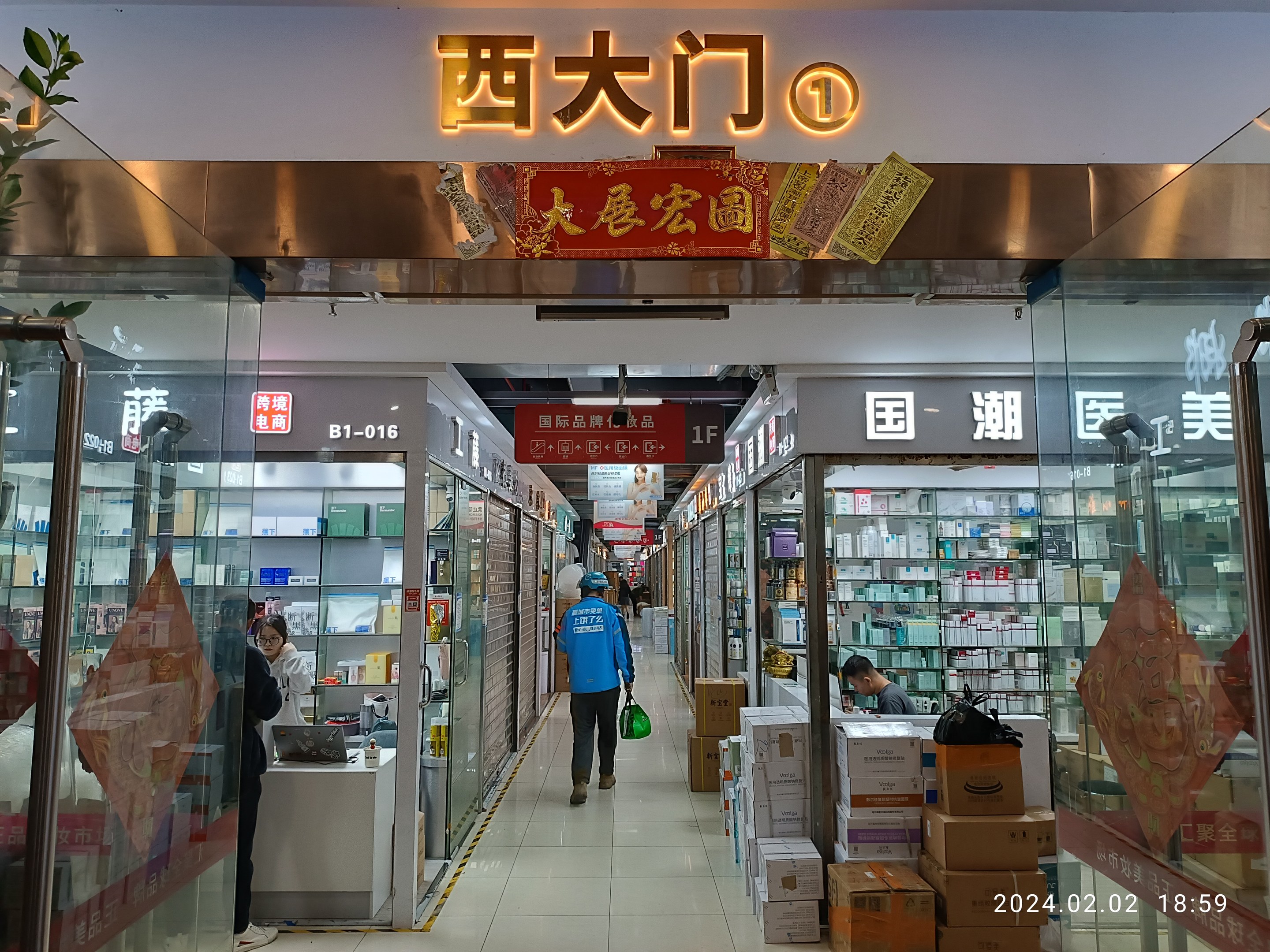 Innenseite einer chinesischen Apotheke mit Glaswänden, Regalen voller Artikel, verstreuten Kartons, einer Pflanze links und einem Namensschild oben, das auf eine chinesische Drogerie hinweist.