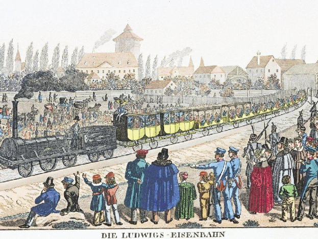 Eine Gruppe von Menschen, die um einen Zug auf einem Gleis herumstehen, wobei einige im Zug sitzen und andere draußen stehen, in der Nähe eines Gebäudes und Bäume, mit Text unten lesend "Ludwigs-Eisenbahn, die erste Bahnstation in Deutschland"