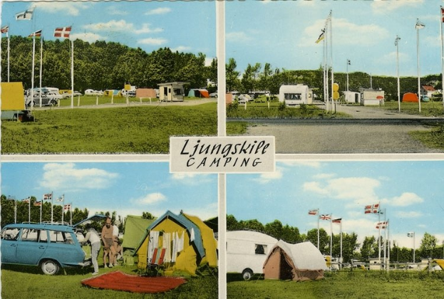 Postkarte eines Campingplatzes mit einem Auto davor, Zelten und Menschen im Hintergrund, Fahnen auf Stangen, Bäumen, einer Straße, bewölktem Himmel und einer Texttafel vorn.